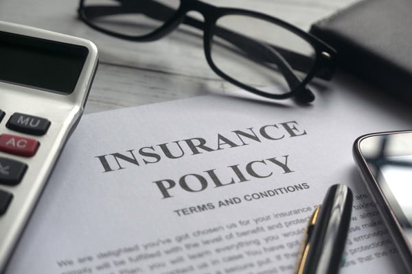 Insurance policy document with terms and conditions on desk.