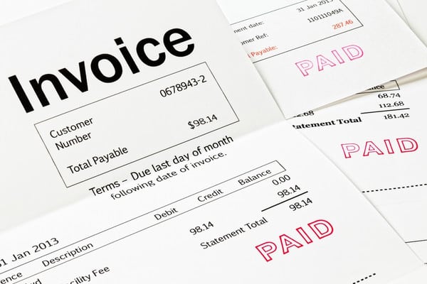 Paid invoice documents showing completed tree service billing.